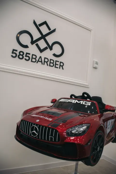 Detské holičské kreslo v tvare červeného auta pred logom 585 BARBER